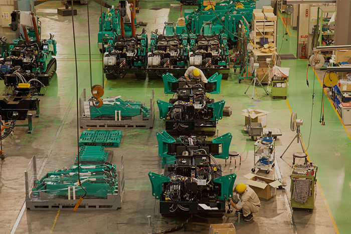 Shot of Mini Cranes and engineers inside MAEDA Seisakusho Co. service factory 