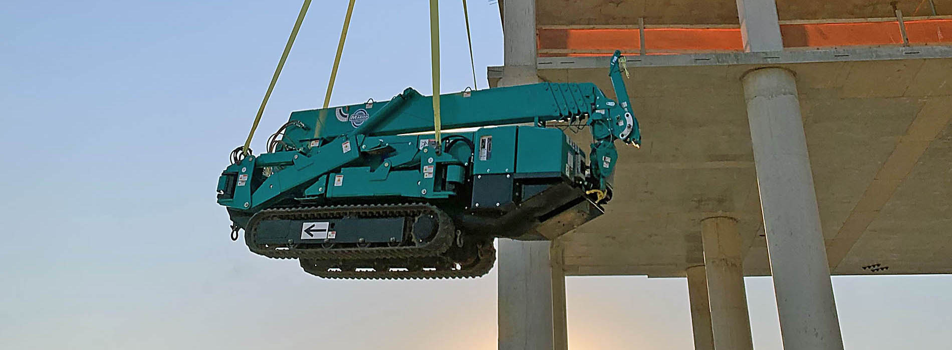 MAEDA Mini Crane being lifted on exterior of building construction zone