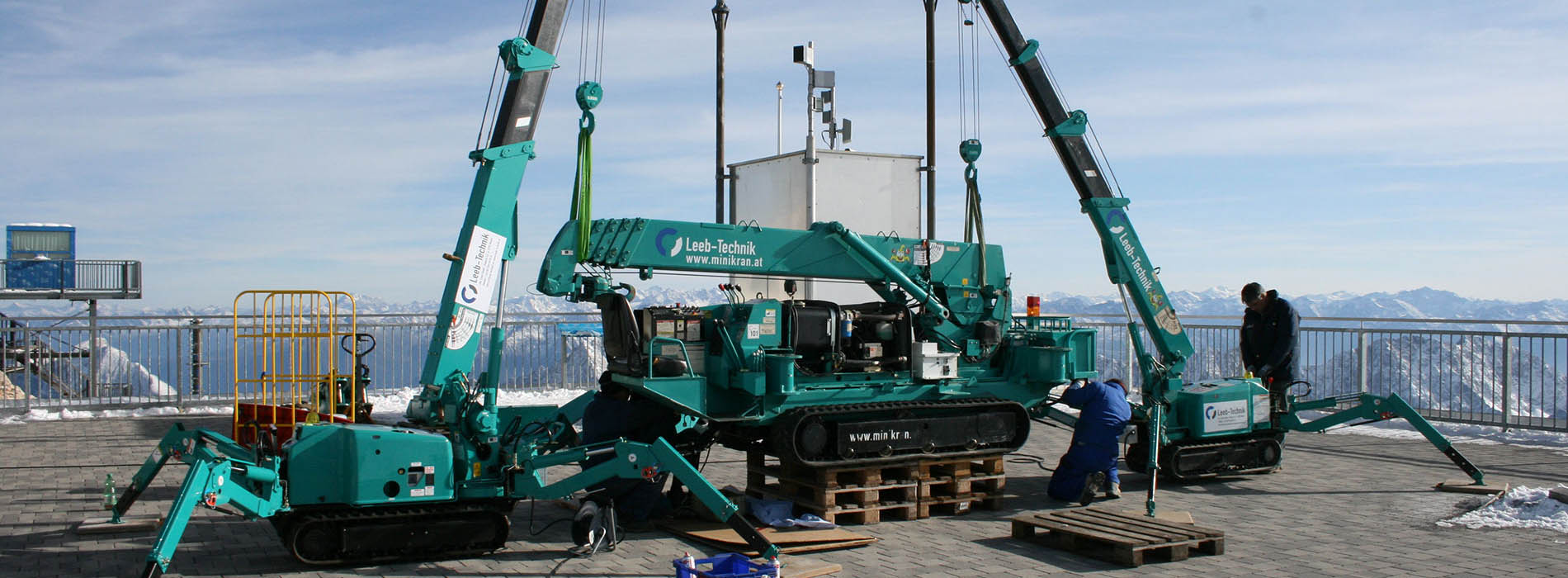 2 MAEDA Mini Cranes lifting machinery on rooftop 